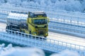 Tanker truck crossing a highway bridge in winter..