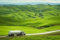 tanker truck driving past green rolling hills Royalty Free Stock Photo