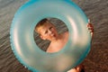 Tanned six-year-old child holding a blue circle for swimming in the summer at sea Royalty Free Stock Photo