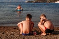 Tanned children playing with sand on the beach