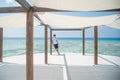 Tanned european handsome young man wearing white t-shirt and black shorts standing at yoga sala at tropical island luxury resort Royalty Free Stock Photo