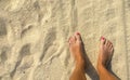 Tanned feet on the hot sand