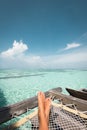 Tanned feet of a woman relaxing on a hammock on the ocean
