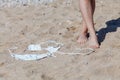Tanned feet of woman and white bikini on sand