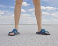 Tanned legs of man wearing flip flops