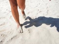 Tanned legs walking on white sand beach Royalty Free Stock Photo