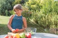 Tanned little girl is a ready to preparing fresh vegetable salad Royalty Free Stock Photo