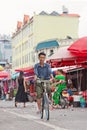 Tanned man cycles on a local outside market, Ruili, China