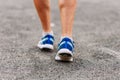 The tanned man feet in sports shoes close outdoors