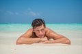 Tanned sexy young man in the ocean in swimming wear at tropical beach at island luxury resort Royalty Free Stock Photo