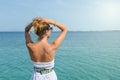 Tanned woman in dress facing seaside. Suumer vacation