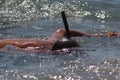 A tanned young male person diving with a black snorkel in the ocean