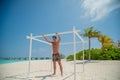 Tanned young man standing near ocean in swimming wear at tropical beach at island luxury resort Royalty Free Stock Photo