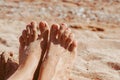 women's feet on the beach by the sea Royalty Free Stock Photo