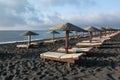 Tanning beds and umbrellas on Perissa beach, Santorini, Greece Royalty Free Stock Photo