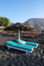 Tanning beds and umbrellas on Perissa beach, Santorini, Greece Royalty Free Stock Photo