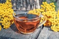 Tansy infusion in a glass cup on a wooden table. Tansy Herbal tea. Healing herbs