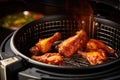 A tantalizing view of chicken wings sizzling on a hot grill, ready to be savored, Frying BBQ chicken wings in a hot air fryer, AI