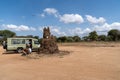 Land Cruiser safari vehicle parked near a large termite mound, as tourists rest and wait before Royalty Free Stock Photo