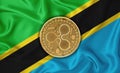 Tanzania flag, ripple gold coin on flag background. The concept of blockchain, bitcoin, currency decentralization in the country.