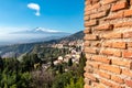 Taormina - Panoramic view of snow capped Mount Etna volcano seen from the ancient Greek theatre of Taormina, island Sicily, Italy Royalty Free Stock Photo