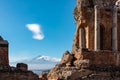 Taormina - Panoramic view of snow capped Mount Etna volcano seen from the ancient Greek theatre of Taormina, island Sicily, Italy Royalty Free Stock Photo