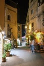 Taormina Sicily, old streets of Taormina during evening with the lights on and people on the terrace