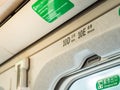 Closeup overhead seat numbers in Taiwan High Speed Rail THSR and Emergency Exit sign with yellow sunlight through the window. Royalty Free Stock Photo