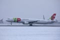 TAP Air Portugal plane taxiing on runway in Munich Airport, Germany, Winter time with snow Royalty Free Stock Photo