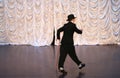 Tap dance with a cane in a black hat. Dance step. A man is dancing on stage Royalty Free Stock Photo