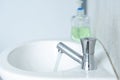 The tap that opens the water in the white bathroom with a hand sanitizer Royalty Free Stock Photo