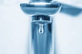 Tap and water drop on blue background Royalty Free Stock Photo