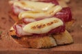 Tapas with Iberico ham, mozzarella cheese, roasted peppers on a slice of toasted baguette with olive oil