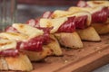 Tapas with Iberico ham, mozzarella cheese, roasted peppers on a slice of toasted baguette with olive oil
