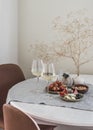 Tapas table - two glasses of white wine, fruit, cheese, nuts in a cozy home environment Royalty Free Stock Photo