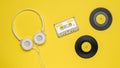 Tape cassette, headphones and vinyl records on a yellow background. Royalty Free Stock Photo