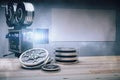 The tape of film and camera on the wooden table and blank picture frame on the wall, mock up Royalty Free Stock Photo