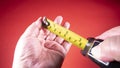 Person holding a flexometer and shows it on a red background Royalty Free Stock Photo