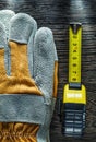 Tape measure pair of safety gloves on wood board Royalty Free Stock Photo