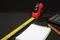 Tape measure pencil and notepad on a dark background Royalty Free Stock Photo