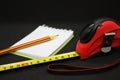 Tape measure pencil and notepad on a dark background Royalty Free Stock Photo