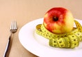 Tape measure and red apple on white plate with fork Royalty Free Stock Photo