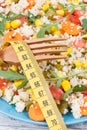 Tape measure and salad with vegetables and couscous groats. Light meal containing healthy vitamins and minerals