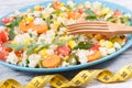 Tape measure and salad with vegetables and couscous groats. Light meal containing healthy vitamins and minerals