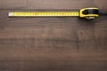 Tape measure on the brown wooden background Royalty Free Stock Photo