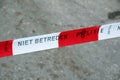 Tape with text do not enter from the dutch police named politie at a crime scene.