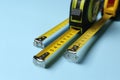 Tapes measure on light blue background, closeup. Construction tool Royalty Free Stock Photo