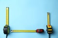 Tapes measure on light blue background, flat lay. Space for text Royalty Free Stock Photo
