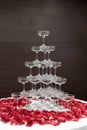 Tapioca pearls in champagne glass pyramid tower decorated with rose petals on white cloth table Royalty Free Stock Photo