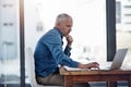 Tapping into new markets within his business expansion plan. a thoughtful mature businessman working on a laptop in an Royalty Free Stock Photo